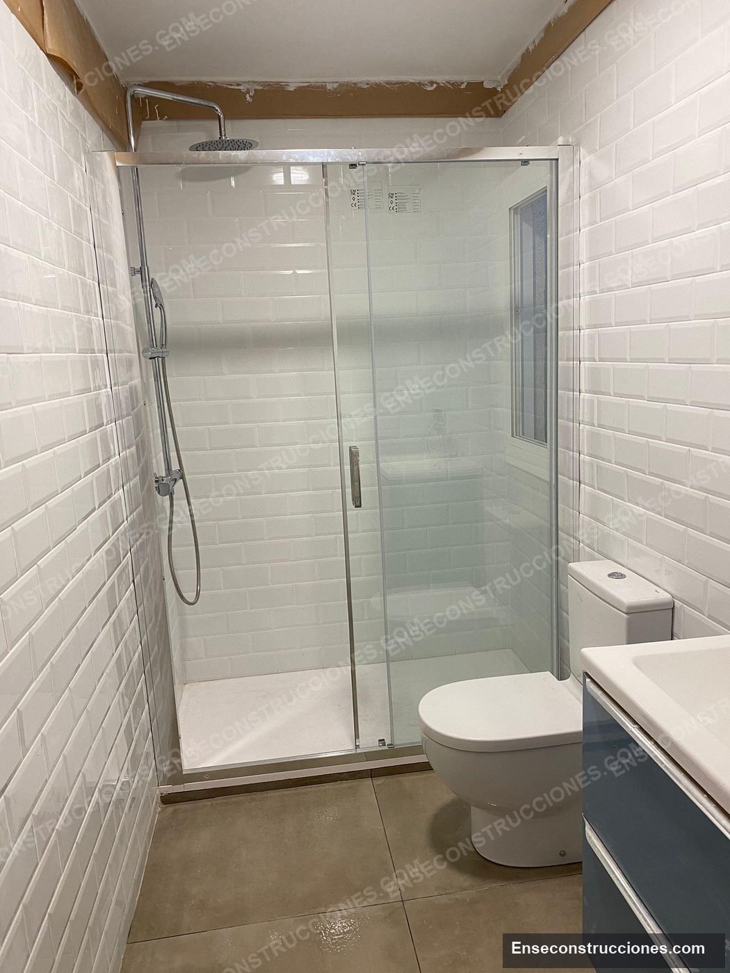 Baño reformado con azulejo metro y ducha de obra