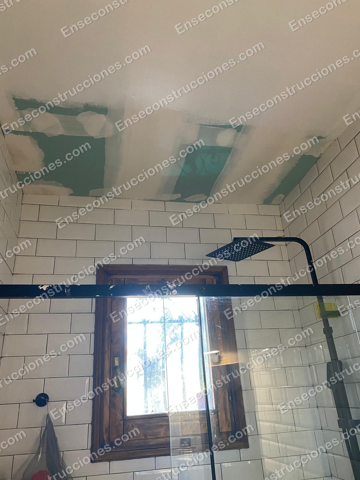Baño terminado con azulejo metro blanco y ducha de lluvia negra reformado por EnsEConstrucciones