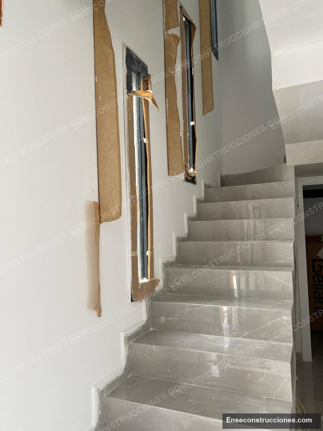 Escalera y pasillo de vivienda con peldaños de gres de gran formato